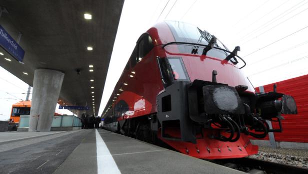 Ein roter Zug steht am Bahnhof Tullnerfeld.