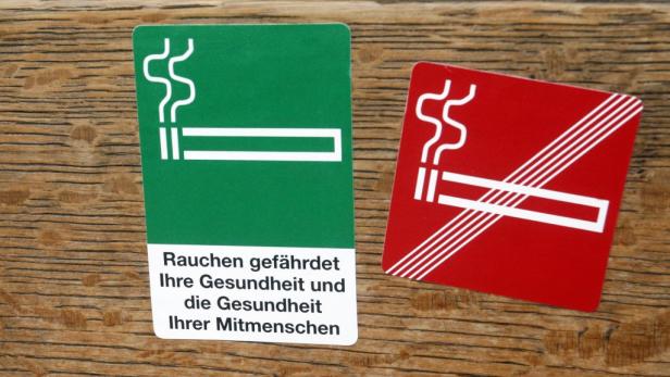 Ein grünes Schild erlaubt das Rauchen, ein rotes verbietet es.