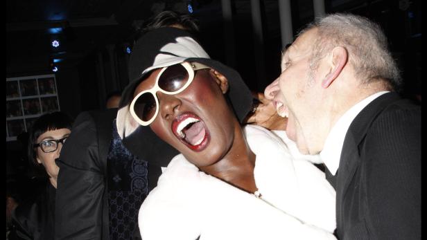 Grace Jones mit offenem Mund neben einem Mann auf einer Veranstaltung.