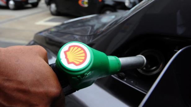 epa03701407 A customer fills his tank with gasoline at a Shell petrol station in London, Britain, 15 May 2013. The office of oil giants BP and Shell were raided by inspectors on 14 May, after allegations of collusion over price-fixing, which may have increased the price of petrol. EPA/ANDY RAIN