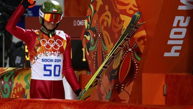 Poland's Stoch reacts after his jump in the first