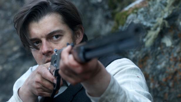 Ein Mann zielt mit einem Gewehr in Richtung des Betrachters.