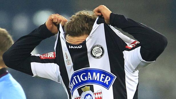 Ein Fußballspieler zieht sein Trikot mit dem Schriftzug „Puntigamer“ über den Kopf.