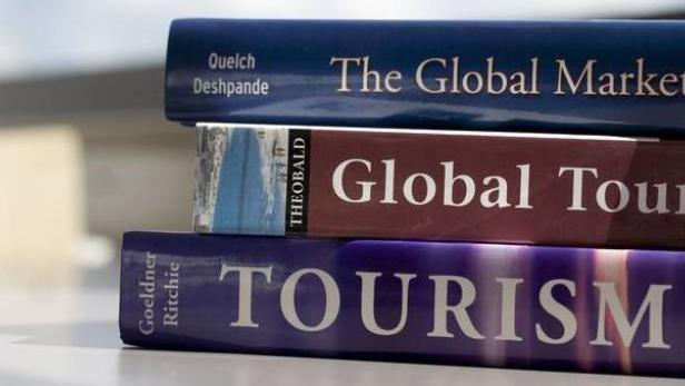 Ein Stapel von drei Büchern über globale Märkte und Tourismus.