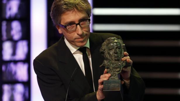 Ein Mann mit Brille hält eine Goya-Statuette in den Händen.