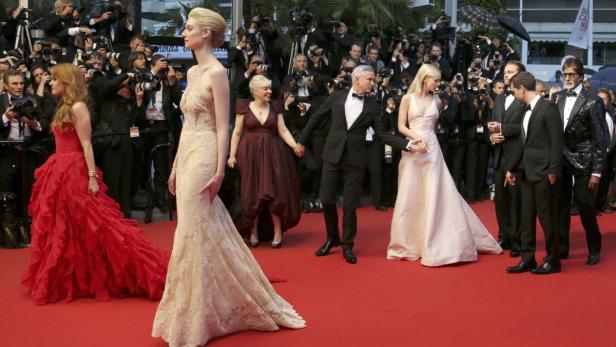 Zahlreiche Prominente posieren auf dem roten Teppich vor einer Wand von Fotografen.