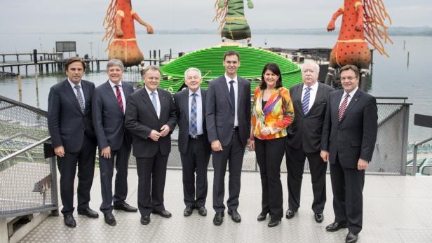 Eine Gruppe von acht Personen posiert vor der Seebühne in Bregenz.