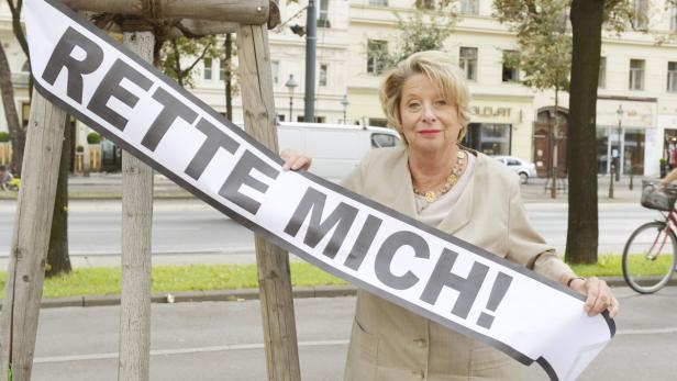 Eine Frau hält ein Transparent mit der Aufschrift „Rette mich!".