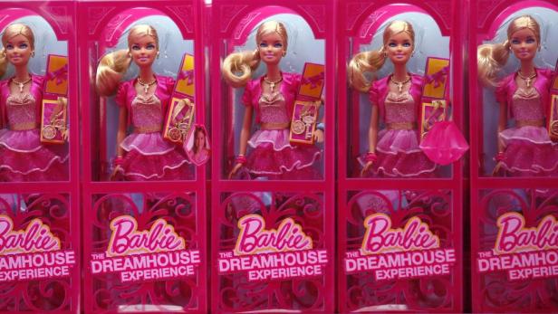 Mehrere „Barbie The Dreamhouse Experience“-Puppen in pinkfarbenen Verpackungen.