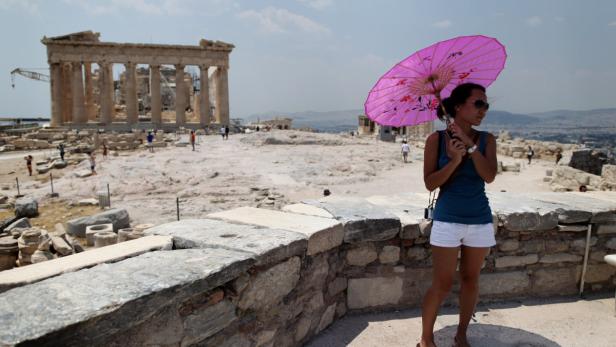 dapdA tourist holds a parasol to avoid the sun as she stands in front of the ancient Parthenon temple at the Acropolis hill in Athens, on Monday July 9, 2012. Temperatures are predicted to reach 39 degrees Celsius, 102.2 Fahrenheit, in Greece. (Foto:Petro "Ich war damals bitter enttäuscht von der angeblichen Wiege der Kultur."