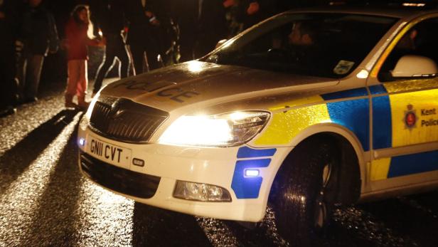 Ein Polizeiauto von Kent steht nachts auf einer nassen Straße.