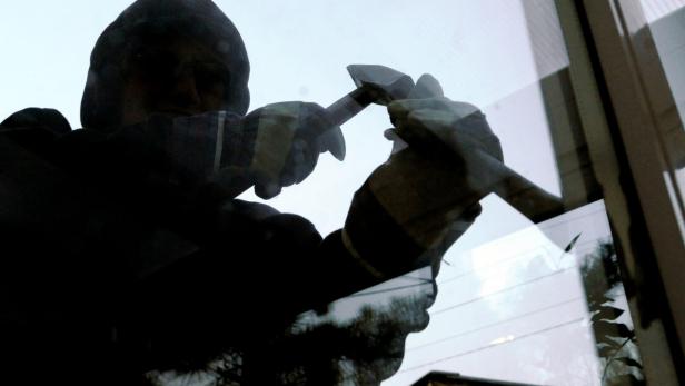 APA2188468-3 - 19042010 - WIEN - ÖSTERREICH: THEMENBILD - Ein maskierter Einbrecher versucht am 19. April 2010 mit einem Brecheisen ein Fenster zu öffnen. (gestellte Szene) APA-FOTO: HERBERT PFARRHOFER