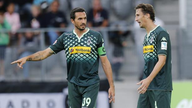 Zwei Fußballspieler von Borussia Mönchengladbach in ihren Trikots auf dem Spielfeld.