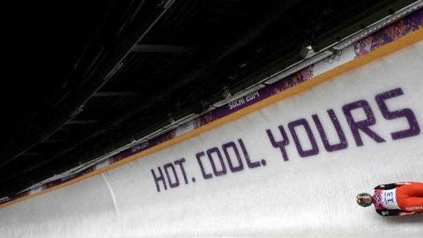 Ein Rennrodler aus Österreich rast eine Eisbahn in Sotschi hinunter.