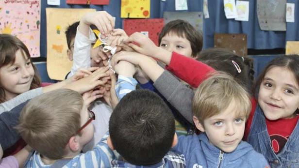 Alle Hände der Kinder der Vorschulgruppe halten das Sackerl mit den &quot;Orden&quot; - für jede und jeden gibt&#039;s einen Anstecker