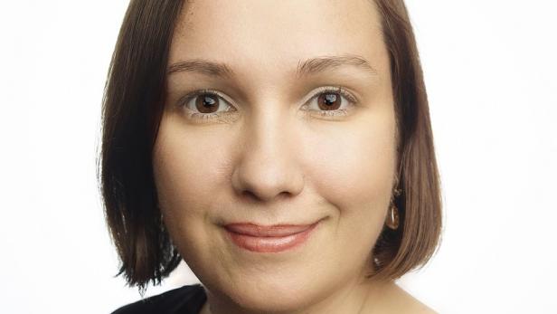 Porträt einer lächelnden Frau mit braunen Augen und braunem Haar.