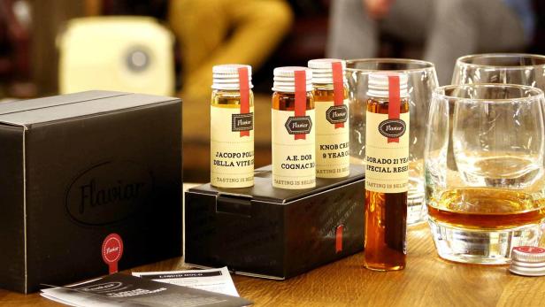 Eine Auswahl an Whisky- und Cognac-Proben von Flaviar, zusammen mit Verkostungsgläsern.