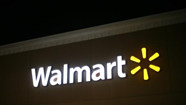 Das beleuchtete Walmart-Logo an der Fassade eines Geschäfts bei Nacht.