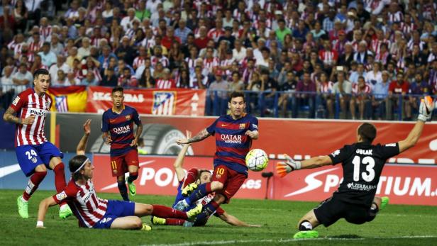 Lionel Messi im Zweikampf mit Spielern von Atlético Madrid während eines Fußballspiels.