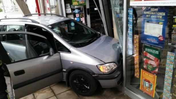 Ein silberner Opel Zafira ist in die Glasfront eines Ladens gefahren.