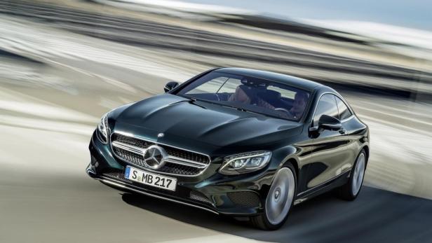 Ein dunkles Mercedes-Benz S-Klasse Coupé fährt auf einer Straße.