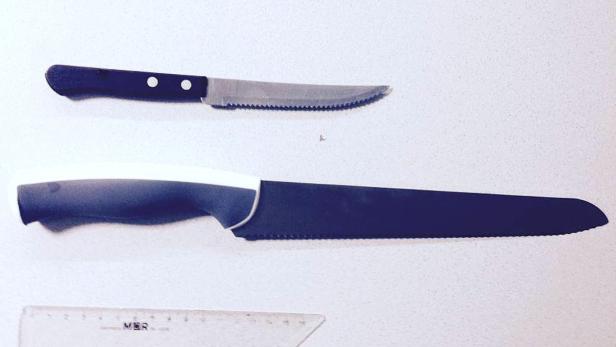 Zwei Messer, ein Steakmesser und ein Brotmesser, liegen auf einer weißen Oberfläche.