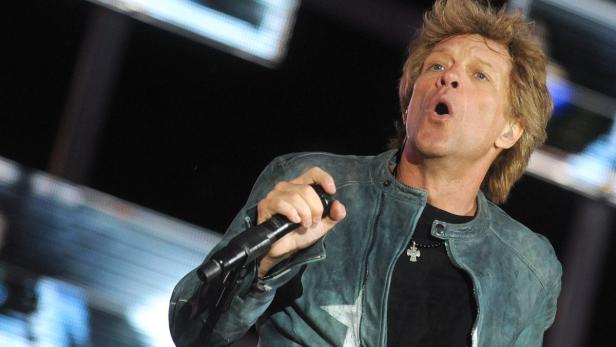Jon Bon Jovi singt während eines Konzerts in ein Mikrofon.