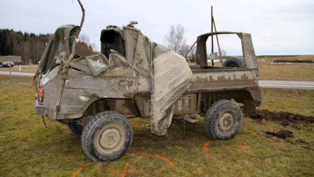 Ein beschädigter Militär-LKW steht auf einer Wiese.