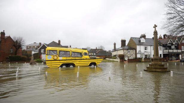 Ein gelbes Amphibienfahrzeug von „Windsor Duck Tours“ fährt durch eine überflutete Straße.