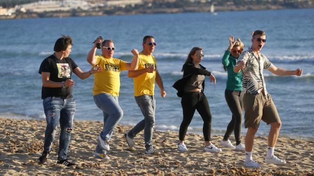 FILE PHOTO: Tourists from Germany dance at El Arenal beach in Palma de Mallorca