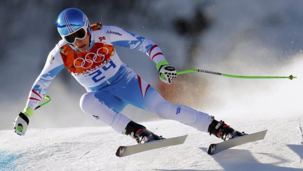 Ein Skirennläufer mit blau-weissem Anzug fährt einen Hang hinunter.