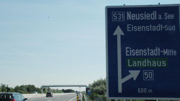 Ein blaues Autobahnschild zeigt die Richtungen Neusiedl am See und Eisenstadt an.
