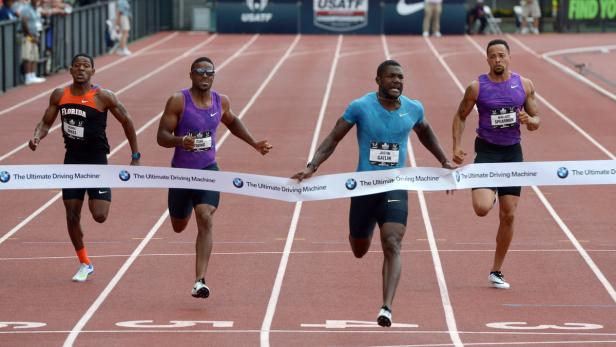 Justin Gatlin und andere Athleten überqueren die Ziellinie bei einem Leichtathletik-Wettkampf.