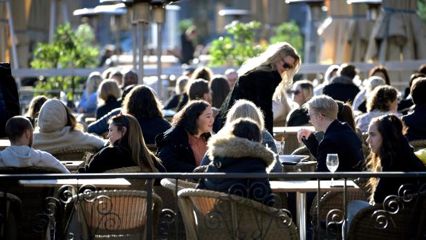 FILE PHOTO: People enjoy the sun at an outdoor restaurant, despite the continuing spread of coronavirus disease (COVID-19), in Stockholm