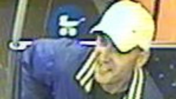 Ein Mann mit einer weißen Kappe steht vor einem Bus mit einem Kinderwagensymbol.