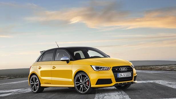 Ein gelber Audi S1 mit schwarzem Dach steht auf einer asphaltierten Fläche.