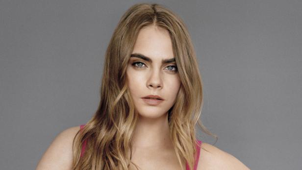 Ein Porträt der Schauspielerin Cara Delevingne mit blonden, gewellten Haaren.