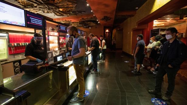 Moviegoers shop at concessions before the movie "Godzilla vs. Kong" on the reopening day of the TCL Chinese theatre during the outbreak of the coronavirus disease (COVID-19), in Los Angeles