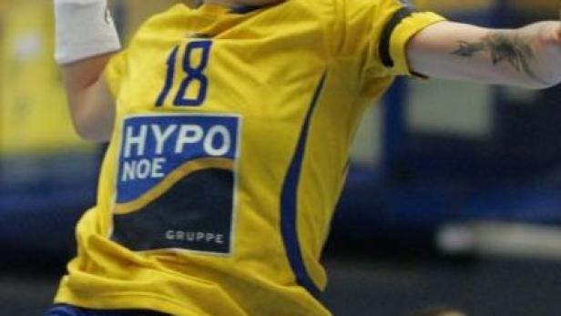 Eine Handballspielerin in gelbem Trikot mit der Nummer 18 wirft den Ball.
