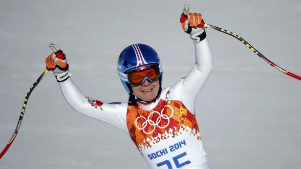 Eine Skirennläuferin jubelt mit erhobenen Armen bei den Olympischen Winterspielen in Sotschi 2014.