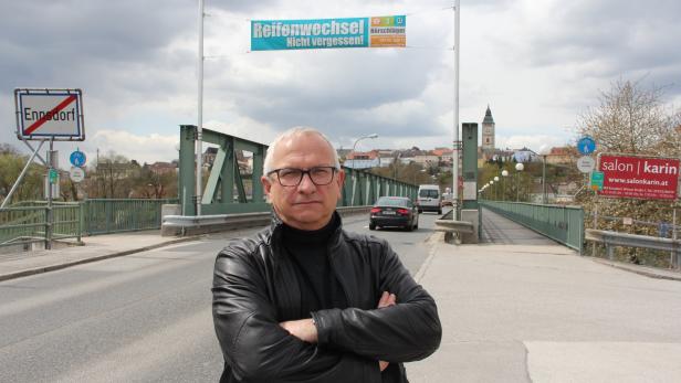 Aktivist im niederösterreichischen Westwinkel: Alfred Buchberger, vor der Brücke über die Enns in die Stadt Enns, berichtet ob der Ungleichbehandlung von Resignation