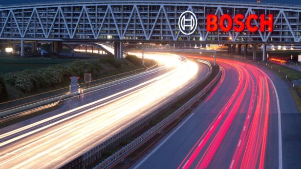 Langzeitbelichtung einer Autobahn unter einem Gebäude mit dem Bosch-Logo.