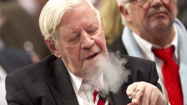 Helmut Schmidt raucht eine Zigarette.