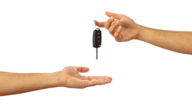 Handing over the car key. Hands isolated on white background, clipping path