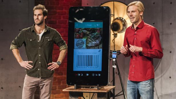Zwei Männer präsentieren eine App für Steakbestellungen auf einem großen Bildschirm.
