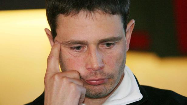 Ein Mann blickt nachdenklich, den Finger an die Schläfe gelegt.