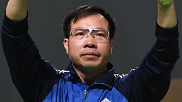 Ein Mann mit Brille hebt die Hände.