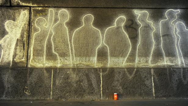 epa03316085 A candle stands in front of a wall with silhouettes at the site of the tragedy of the 2010 Loveparade in Duisburg, Germany, 24 July 2012. Two years after the catastrophic mass panic, Duisburg residents, friends and family members commemorate the 21 victims. The victims died at the entry gates of the parade during a mass panic. EPA/CAROLINE SEIDEL