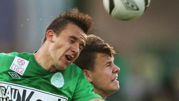 Zwei Fußballspieler kämpfen um einen Ball in der Luft.