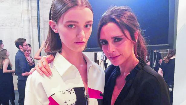 Victoria Beckham posiert mit einem Model Backstage bei einer Modenschau.